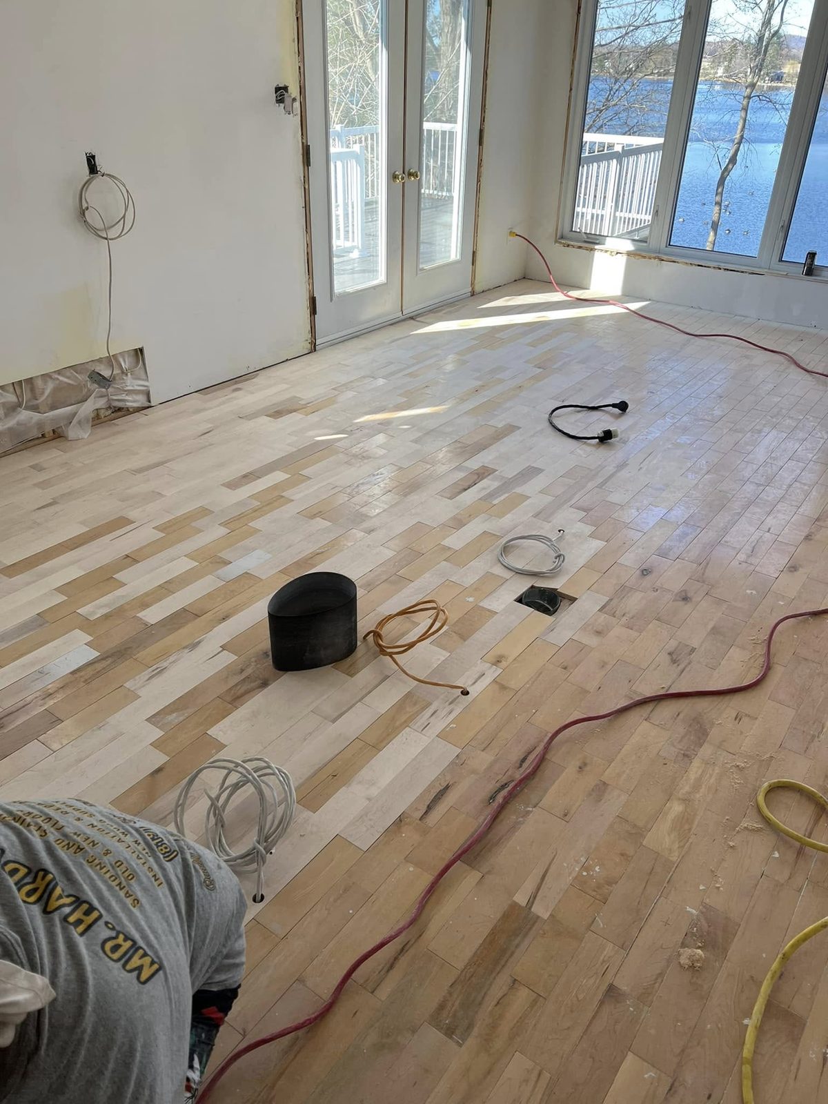 L'équipe de Mr. Hardwood au travail sur un plancher de bois franc d'une résidence au bord de l'eau