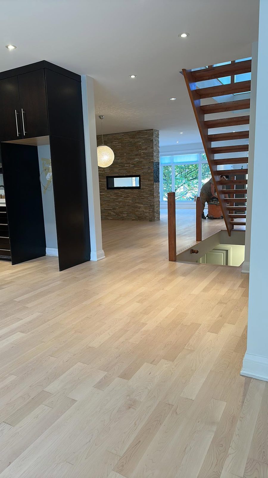 Plancher de bois franc pâle dans un espace contemporain avec escalier suspendu